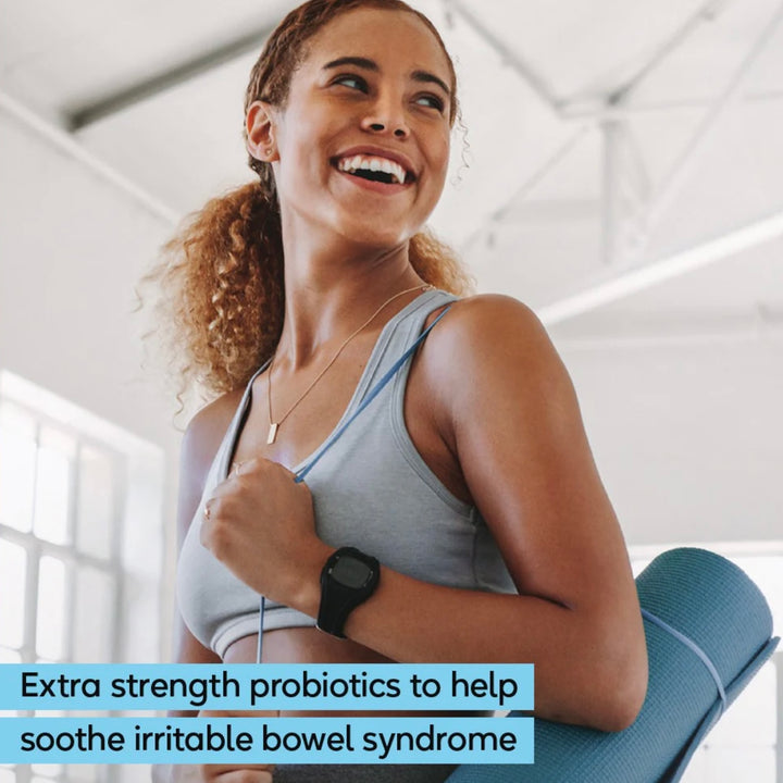 Woman holding a yoga mat indoors with text about probiotics for irritable bowel syndrome.
