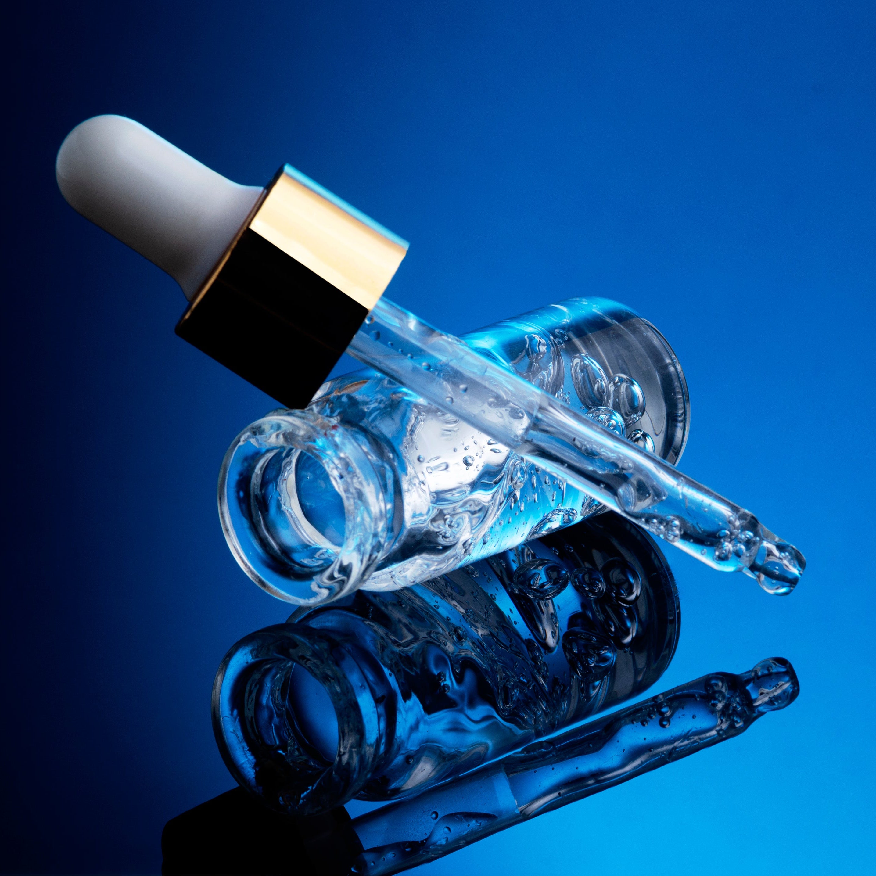 Glass dropper bottle with a blue gradient background