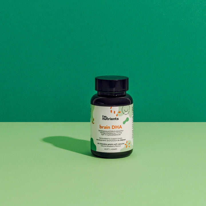Bottle of brain DHA supplement on a green background