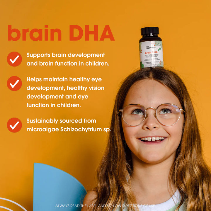 Child with glasses and a bottle of brain DHA supplement on head against an orange background