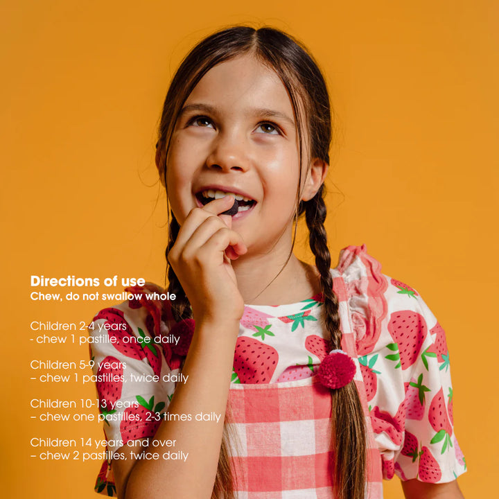 Young girl eating a strawberry with product directions on an orange background