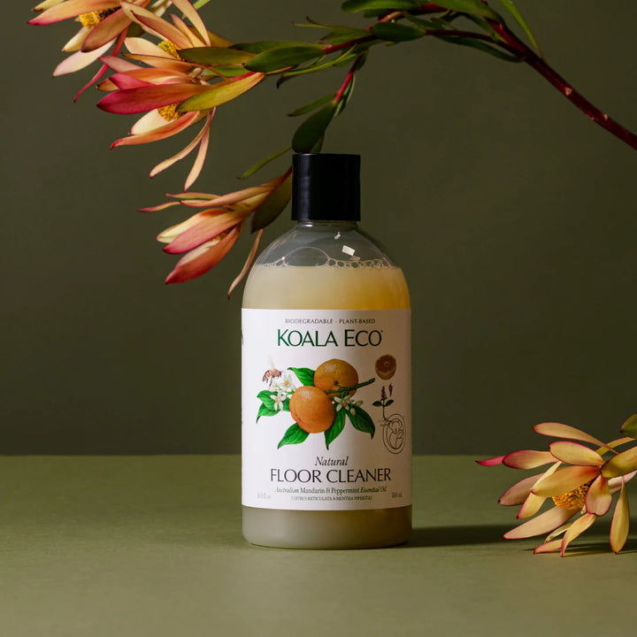 Koala Eco floor cleaner bottle with flowers on a green background