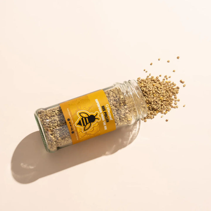 Jar of bee pollen with a yellow label on a beige background