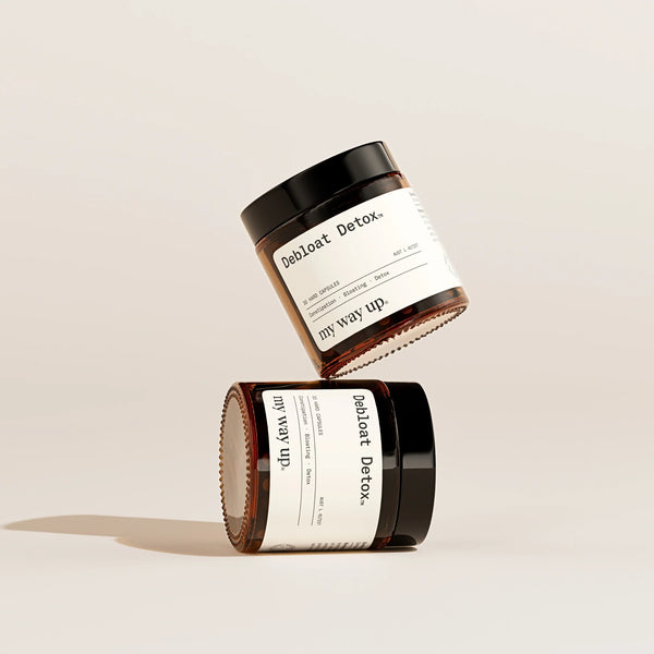 Two jars of 'Debloat Detox' by 'my way up' on a beige background
