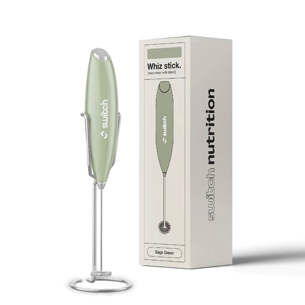 Green handheld mixer with packaging on a white background