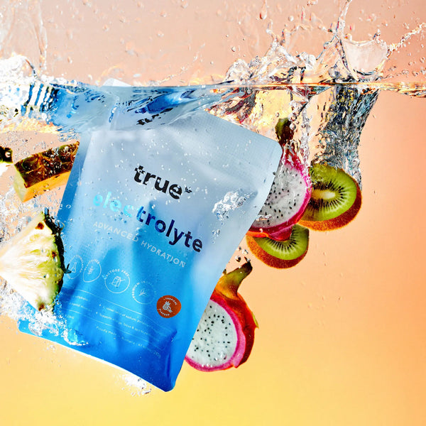 true electrolyte package with fruits in water on a gradient background