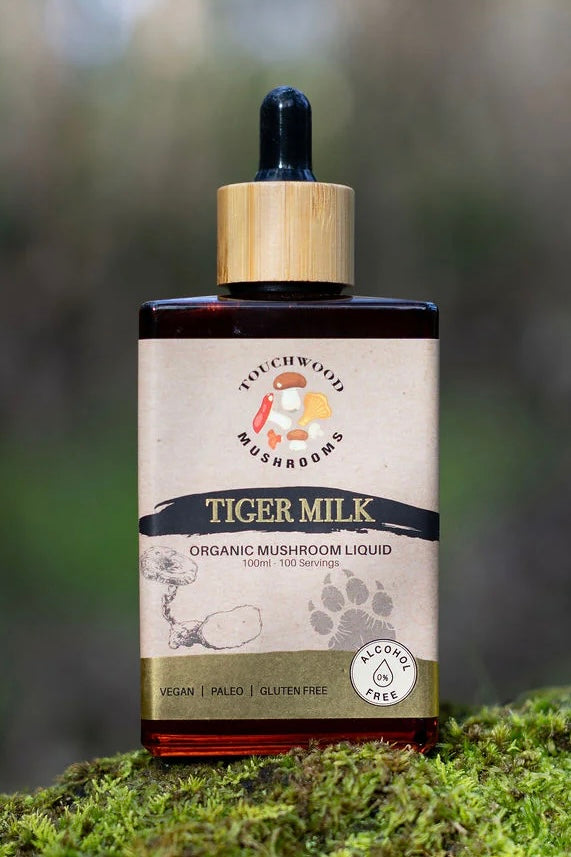 Bottle of Tiger Milk organic mushroom liquid on a mossy background